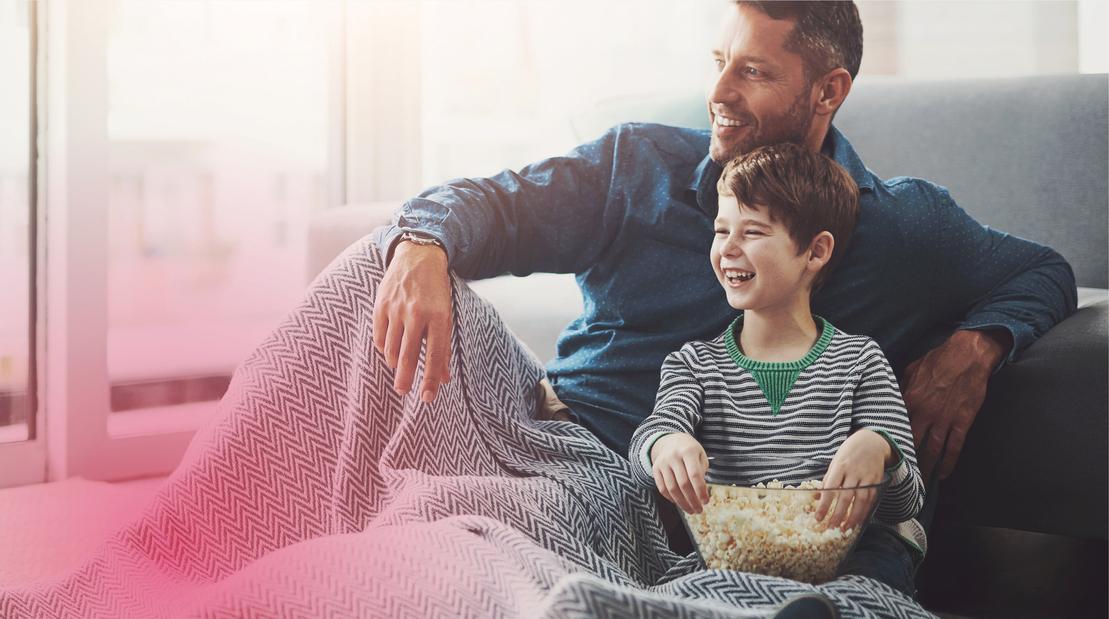 Gas Stadtwerke Ostmünsterland - Ein Mann und ein Junge sitzen gemütlich im warmen Wohnzimmer Gas Stadtwerke Ostmünsterland - Ein Mann und ein Junge sitzen gemütlich im warmen Wohnzimmer