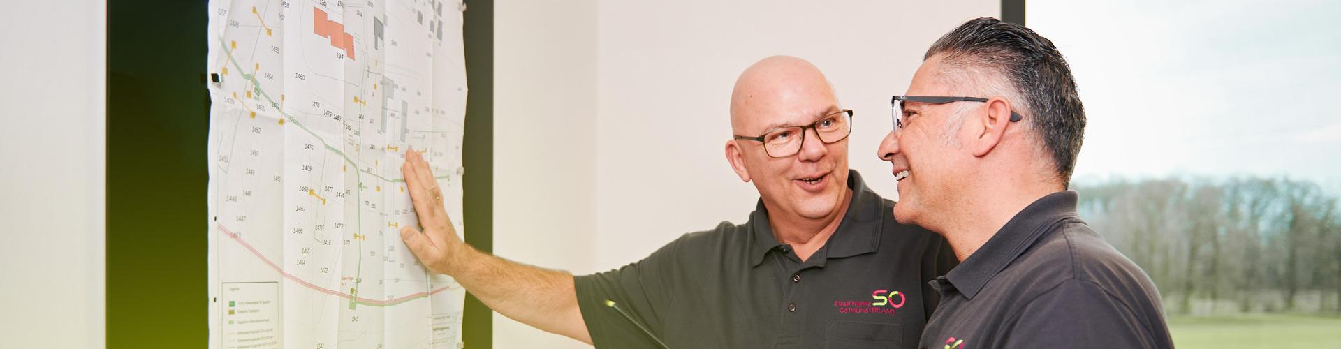 Zwei Meister schauen einen Netzplan an Zwei Meister schauen einen Netzplan an