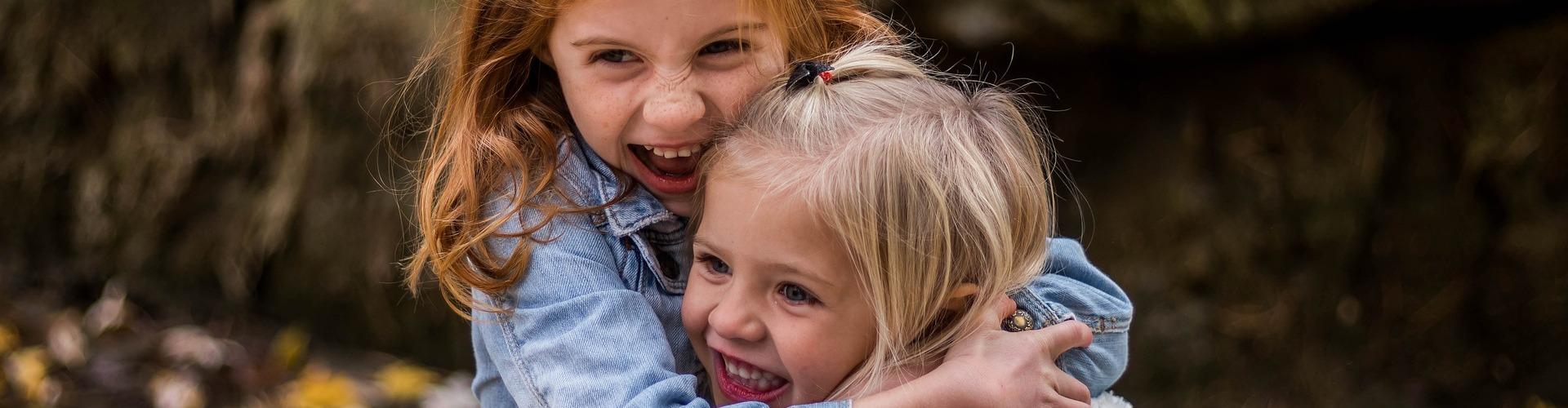 Zwei Mädchen umarmen sich herzlich im Wald Zwei Mädchen umarmen sich herzlich im Wald
