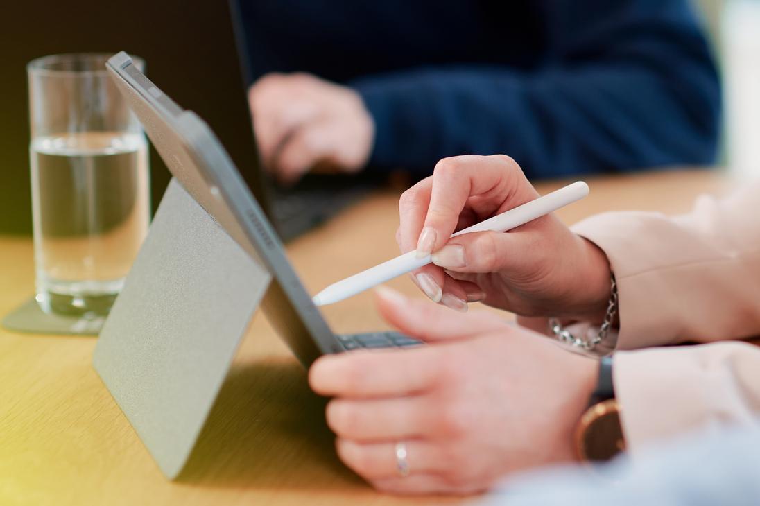 Eine Frau tippt mit einem Stift auf einem Tablet Eine Frau tippt mit einem Stift auf einem Tablet