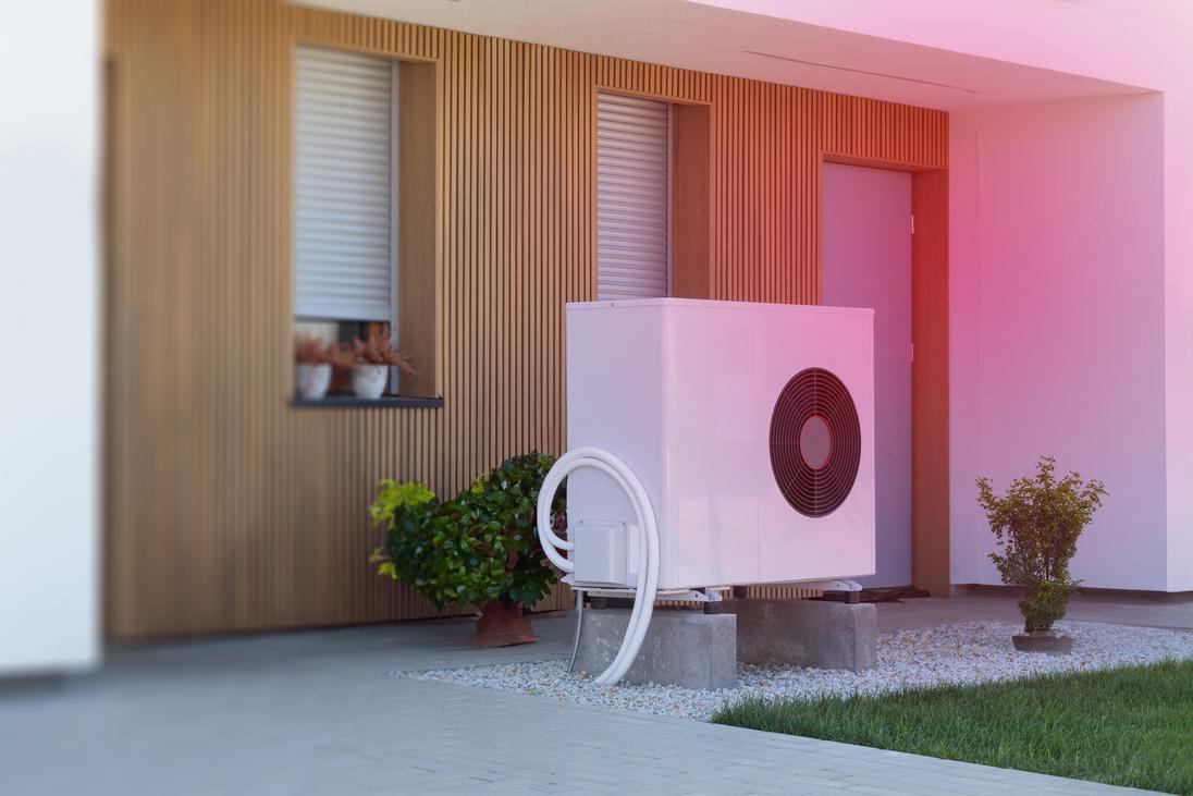 Eine Luft-Wärmepumpe vor einem Haus Eine Luft-Wärmepumpe vor einem Haus