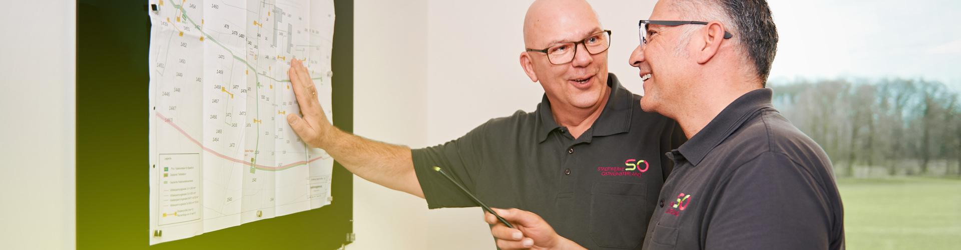 Zwei Meister schauen einen Netzplan an Zwei Meister schauen einen Netzplan an