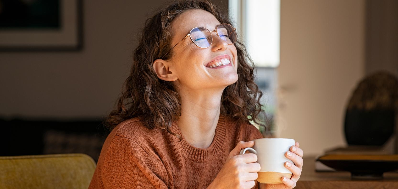 Eine Frau hält eine Tasse in der Hand Eine Frau hält eine Tasse in der Hand