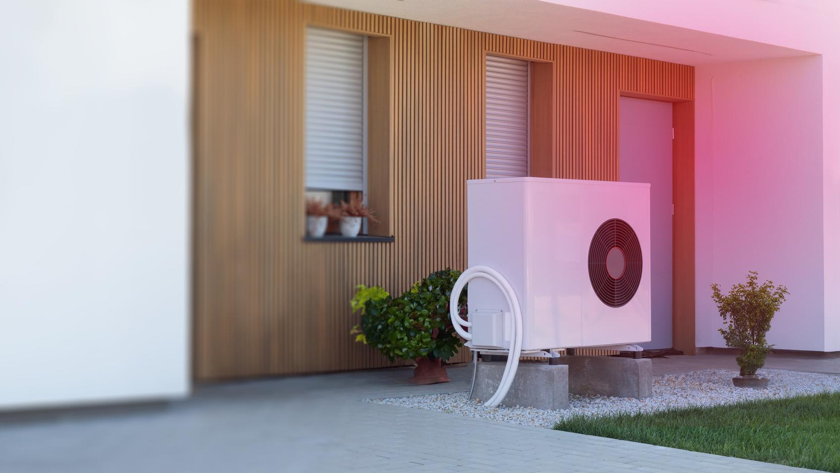 Eine Luft-Wärmepumpe vor einem Haus Eine Luft-Wärmepumpe vor einem Haus