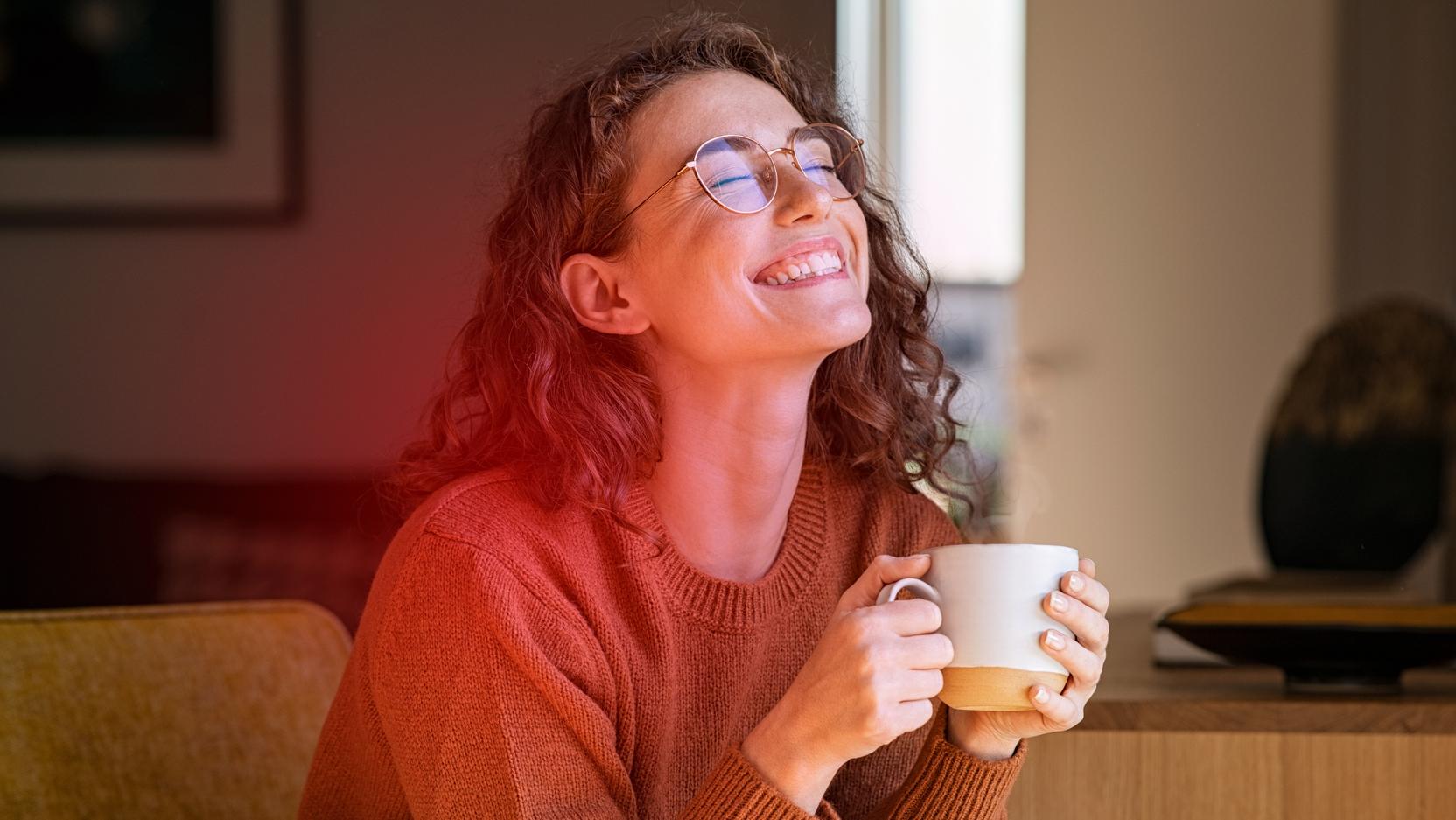 Eine Frau hält eine Tasse in der Hand Eine Frau hält eine Tasse in der Hand