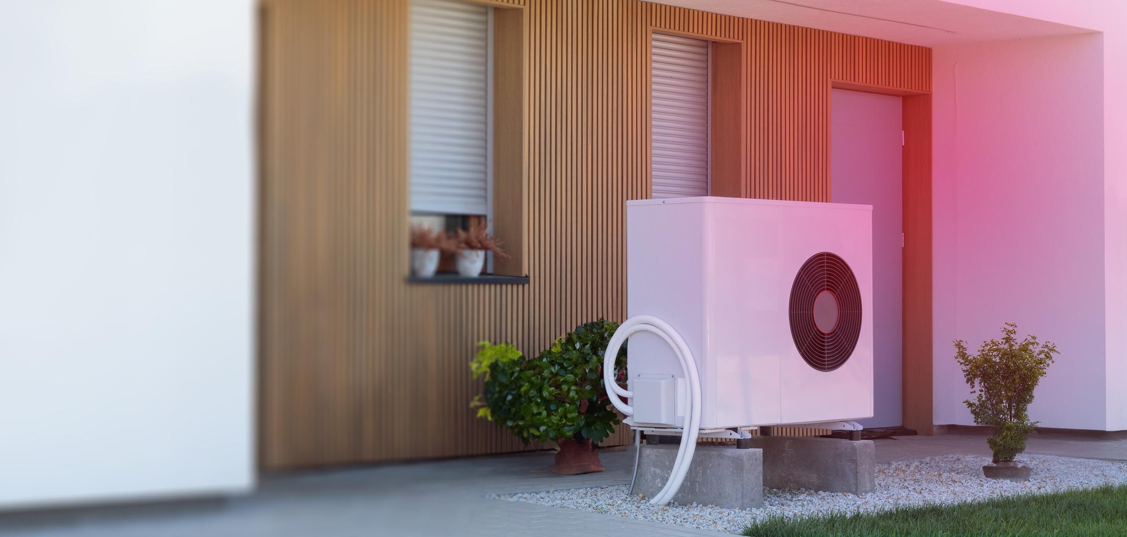 Eine Luft-Wärmepumpe vor einem Haus Eine Luft-Wärmepumpe vor einem Haus