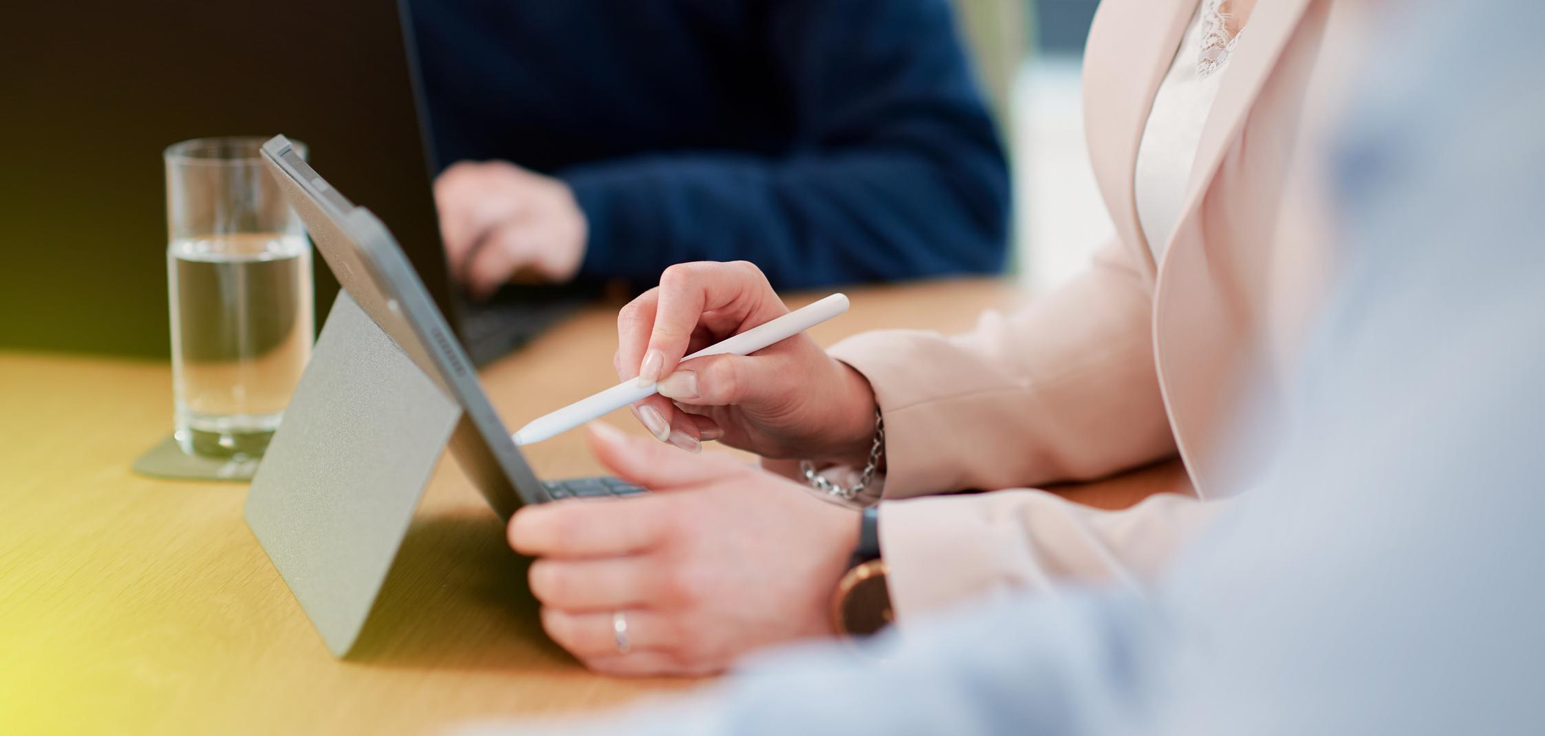 Eine Frau tippt mit einem Stift auf einem Tablet Eine Frau tippt mit einem Stift auf einem Tablet