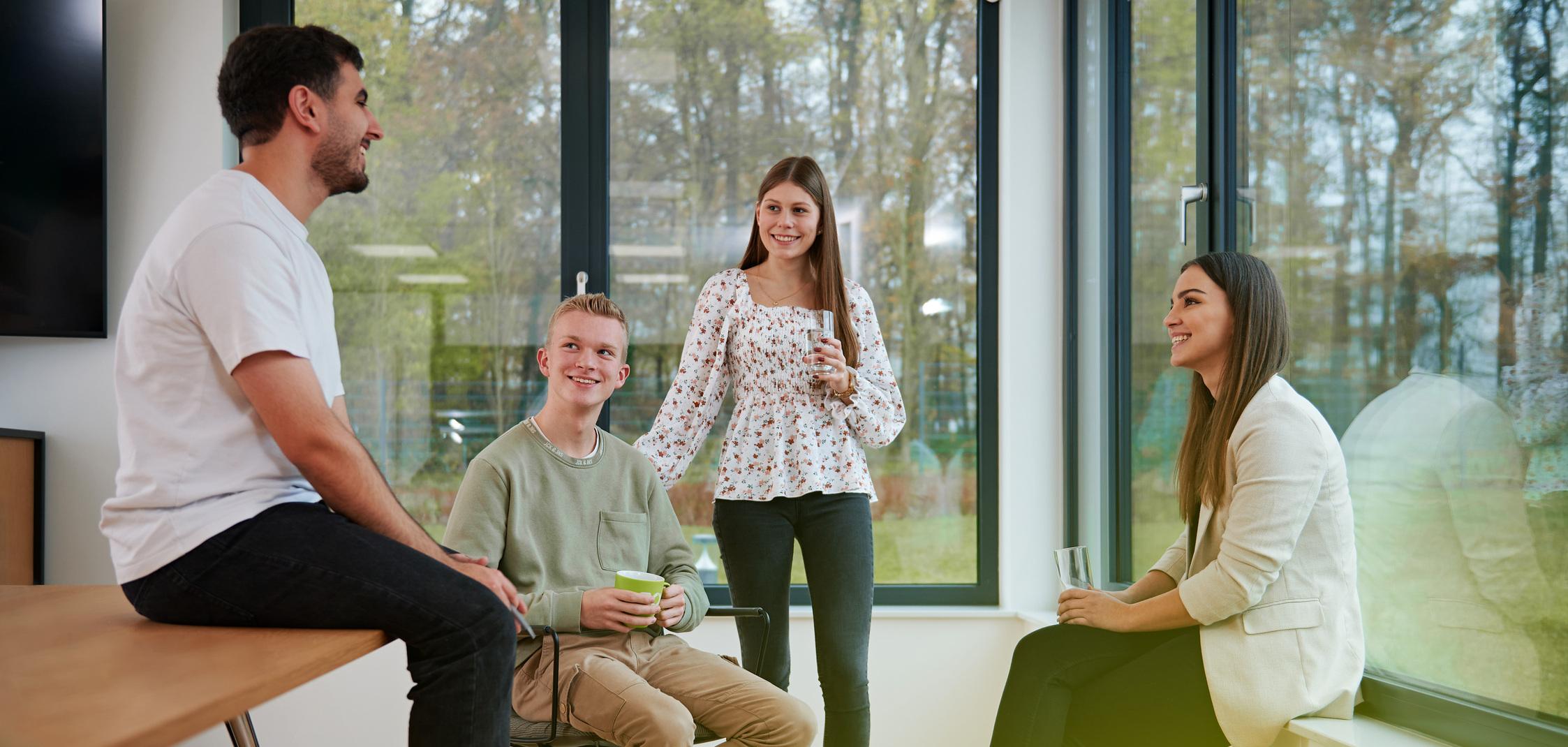 Vier Azubis der Stadtwerke Ostmünsterland sitzen entspannt zusammen Vier Azubis der Stadtwerke Ostmünsterland sitzen entspannt zusammen