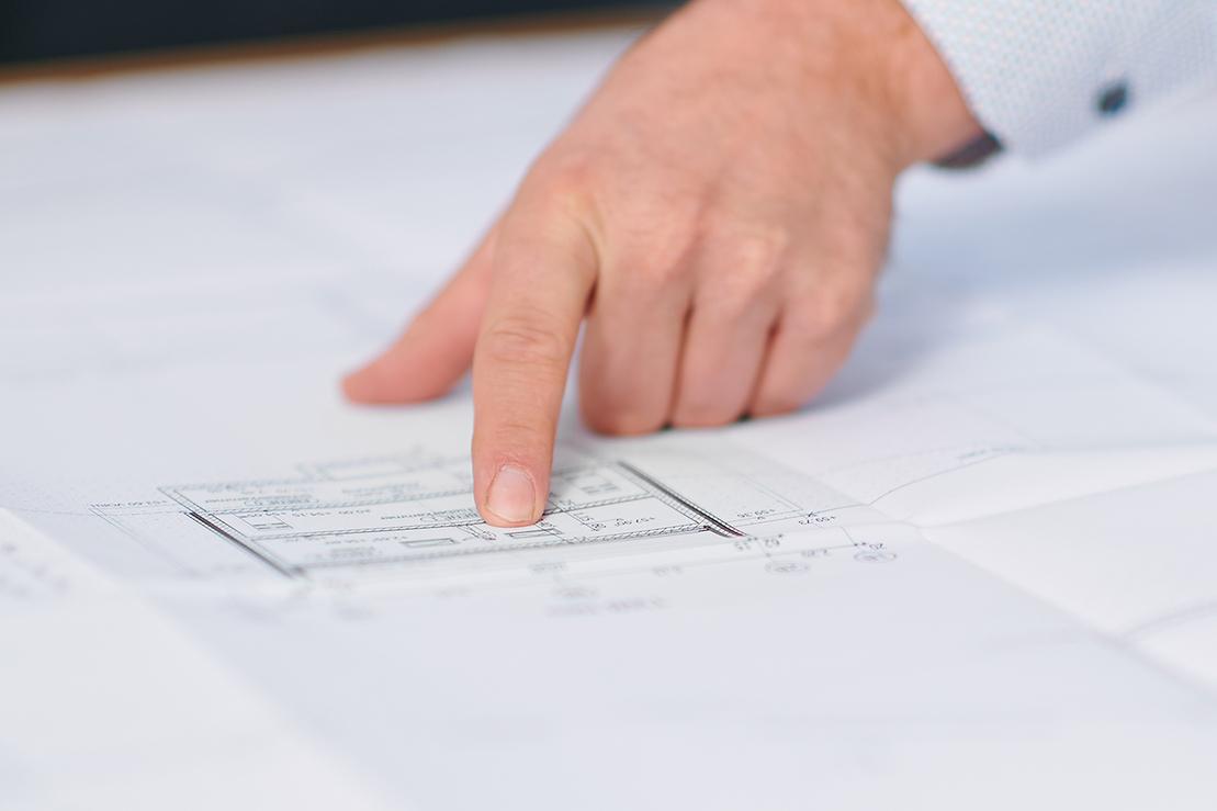 Ein Finger zeigt auf einen technischen Plan Ein Finger zeigt auf einen technischen Plan