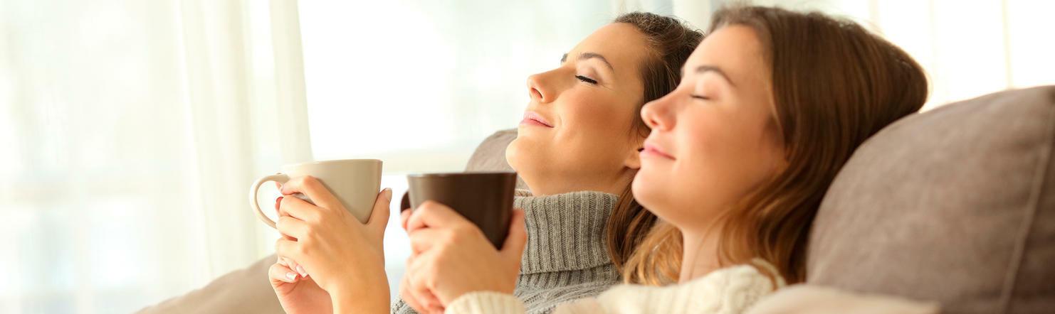 Zwei Frauen entspannen mit einem Kaffee in der Hand Zwei Frauen entspannen mit einem Kaffee in der Hand