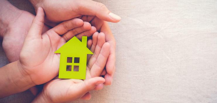 Mehrere Hände halten ein kleines Haus Mehrere Hände halten ein kleines Haus